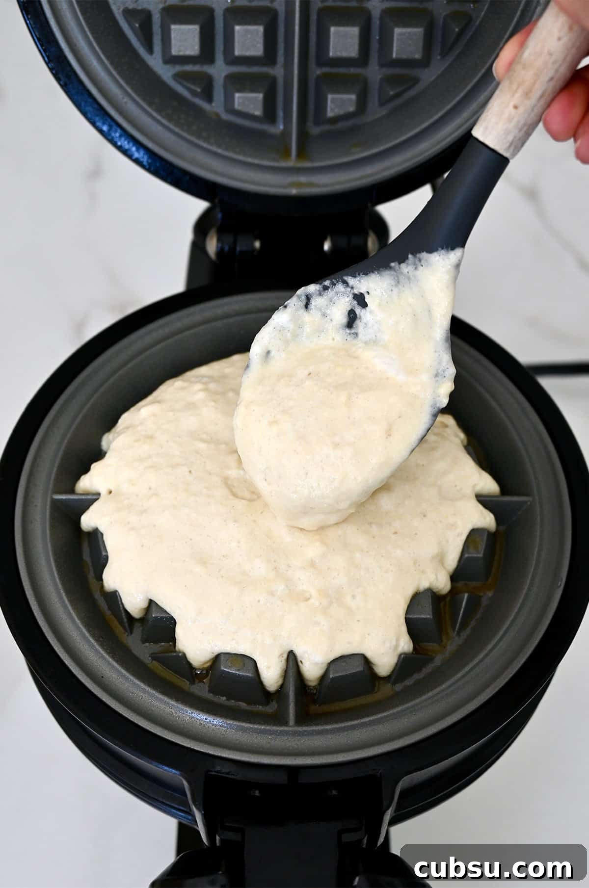 Crispy Belgian Waffles Recipe for Brunch and Weekend Mornings 10 Adding waffle batter to a preheated and well-greased waffle iron.
