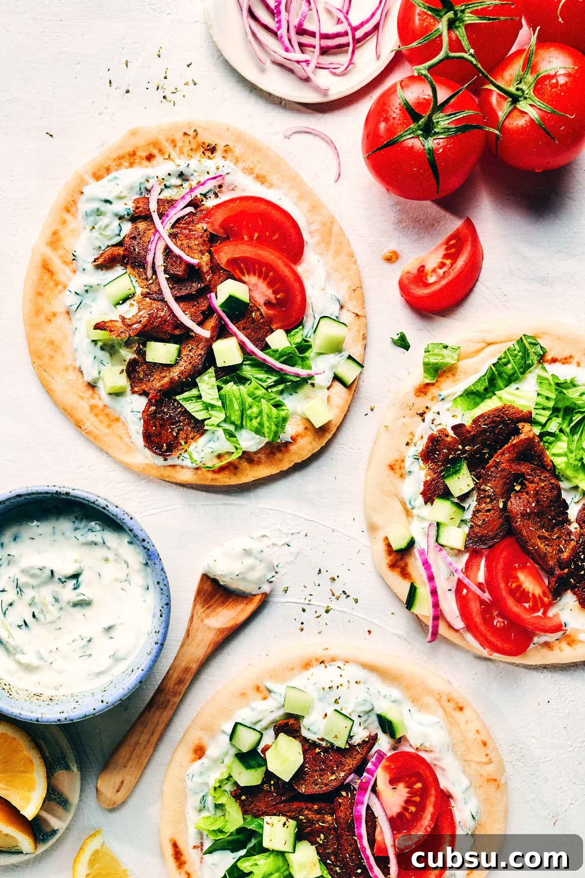 Seitan Vegan Gyros: Flavorful Plant-Based Greek Wrap Recipe 14 Greek gyros on a counter topped with fresh veggies and tzatziki