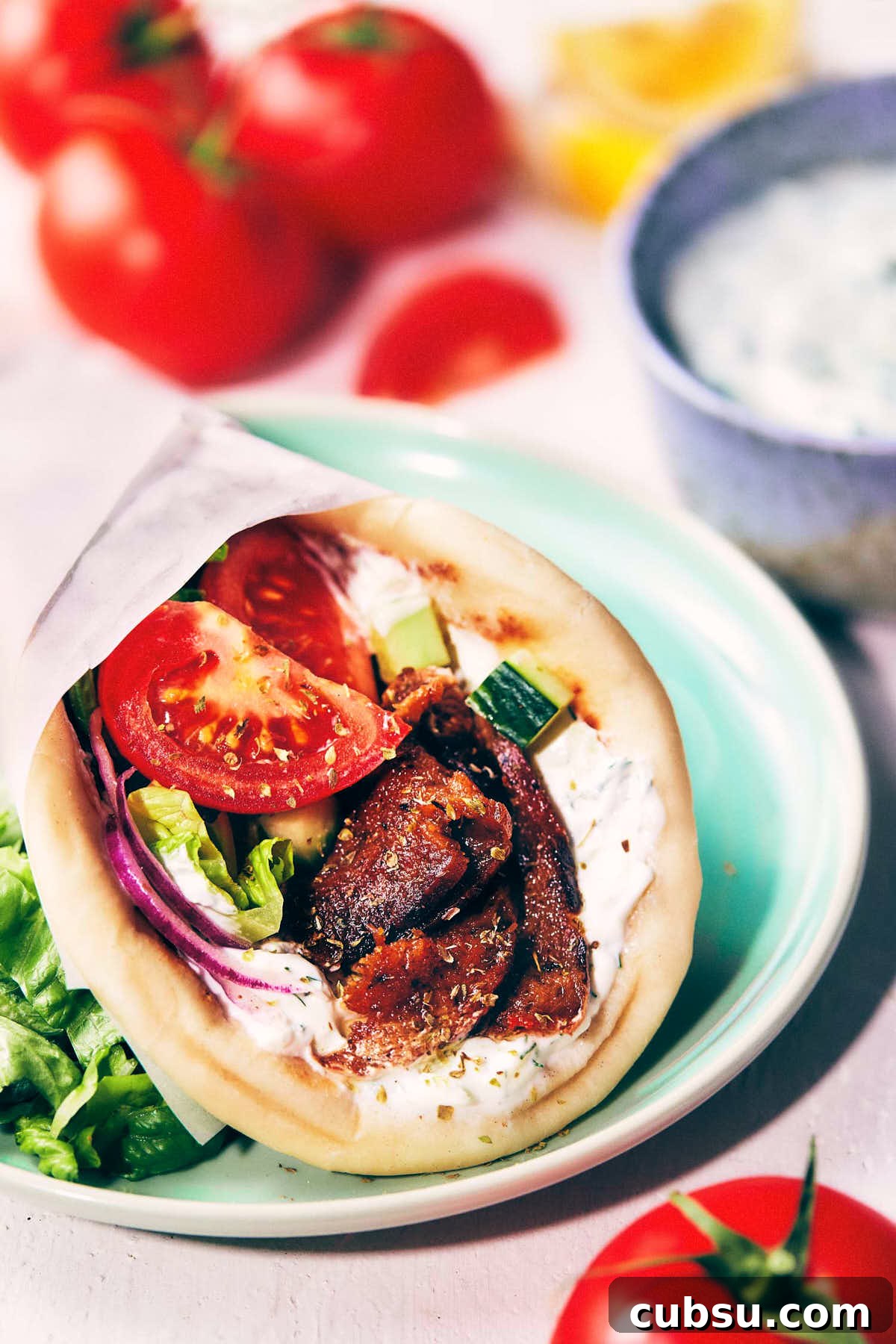 Seitan Vegan Gyros: Flavorful Plant-Based Greek Wrap Recipe 16 Close up of rolled up greek gyros on a light blue plate