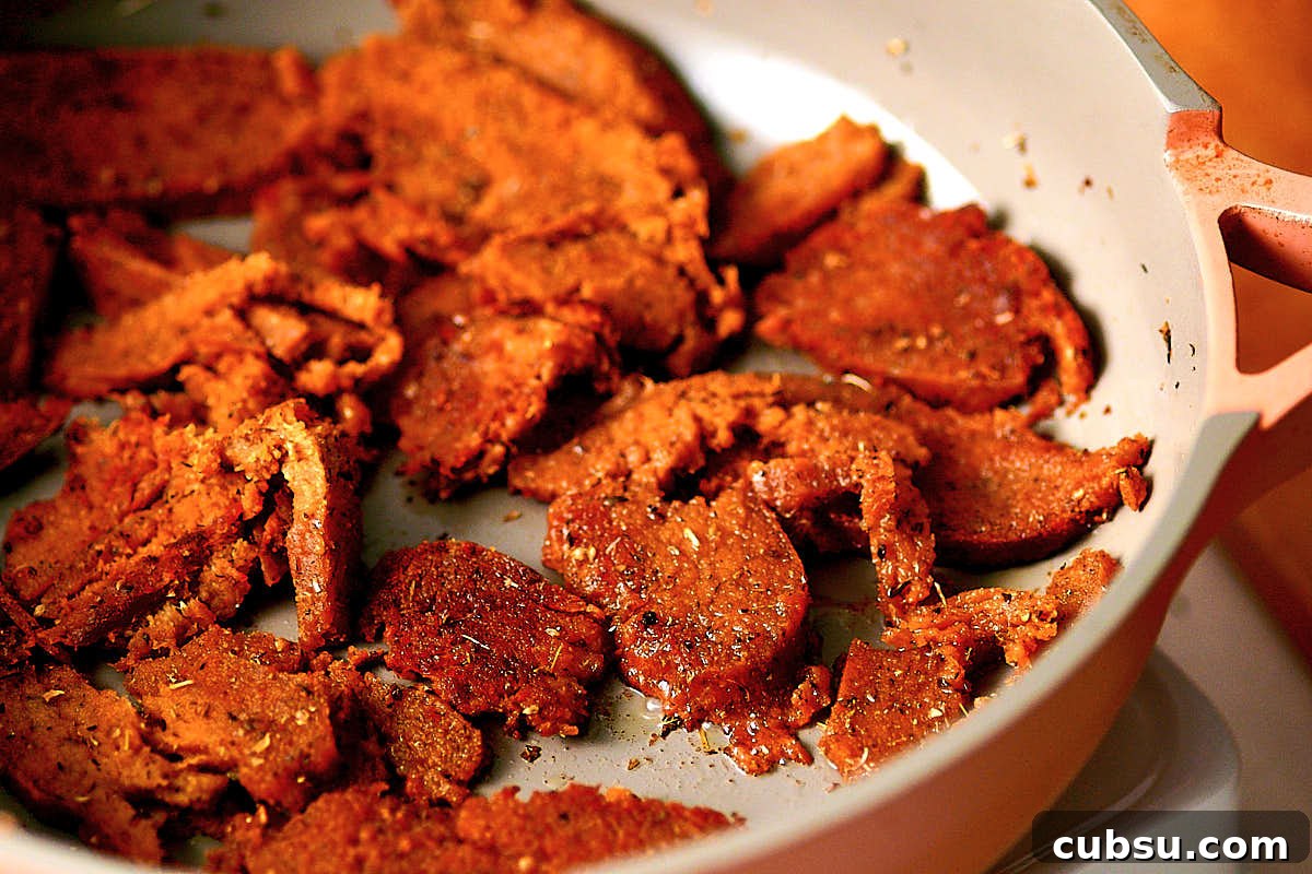 Seitan Vegan Gyros: Flavorful Plant-Based Greek Wrap Recipe 10 Crisping seitan in a nonstick frying pan for vegan gyros recipe.