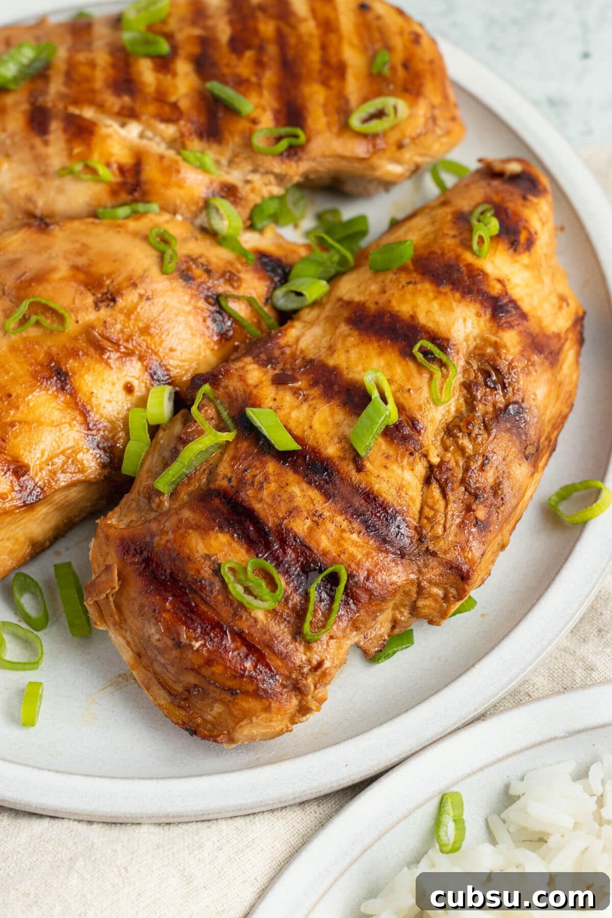 Grilled Filipino Adobo Chicken Recipe for Smoky, Tangy Flavor 3 Grilled chicken adobo, sliced and arranged on a platter with rice.