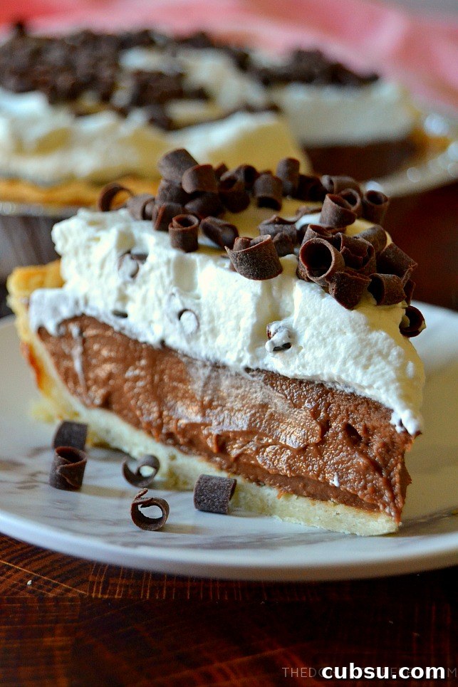 Closeup slice of chocolate cream pie on a white plate with chocolate curls