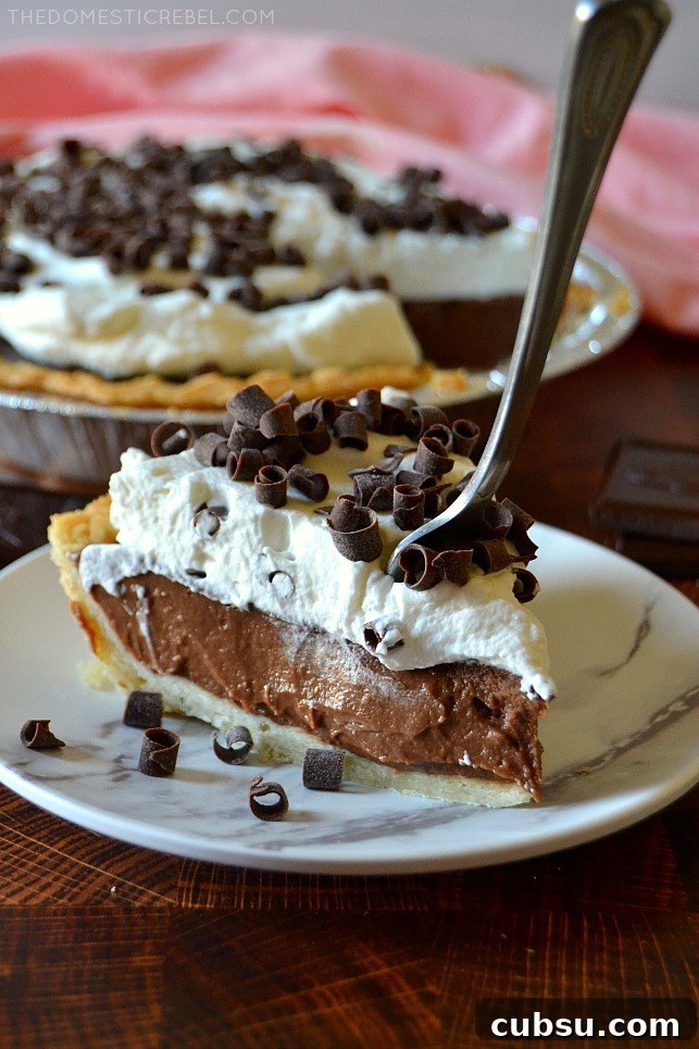 Slice of chocolate cream pie with a fork sticking in it