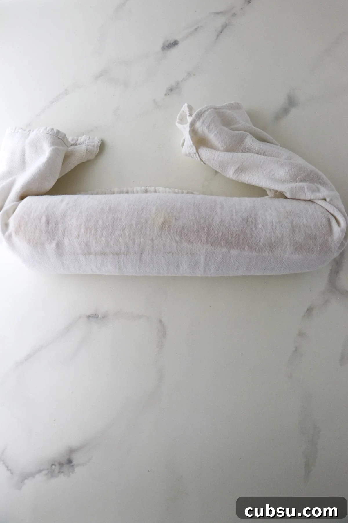 Rolled up rulltårta in a kitchen towel.