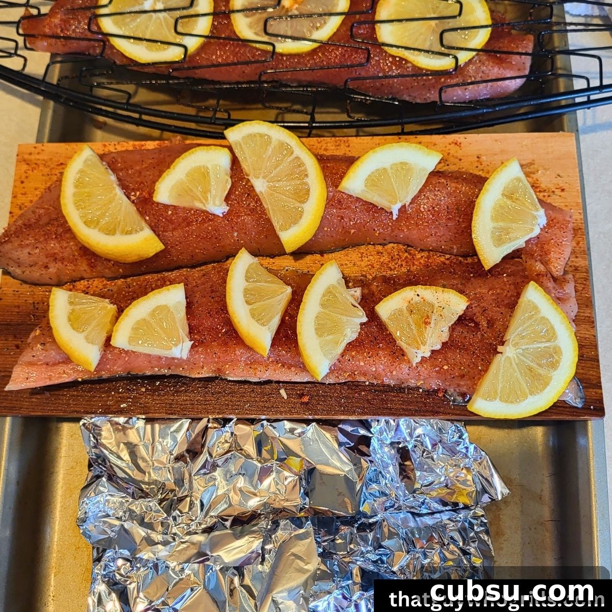 Cedar plank salmon, Foil Salmon, and fish basket salmon ready to grill seasoned and lemon wedges on it