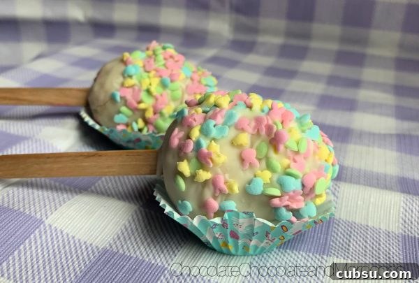 Easter Egg Cake Pops 2 Easter Egg Cake Pops sitting in mini cupcake holders on a purple and white plaid background.
