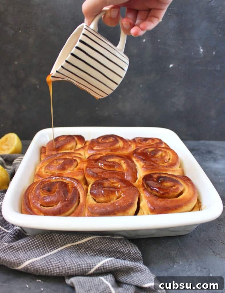 Lemon Glazed Sweet Rolls Recipe – Soft, Zesty Breakfast Buns 5 Pouring the lemon caramel over the bread rolls.