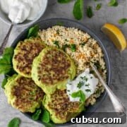 Four pea fritters in a bowl with a portion of couscous. and a dollop of greek yoghurt.