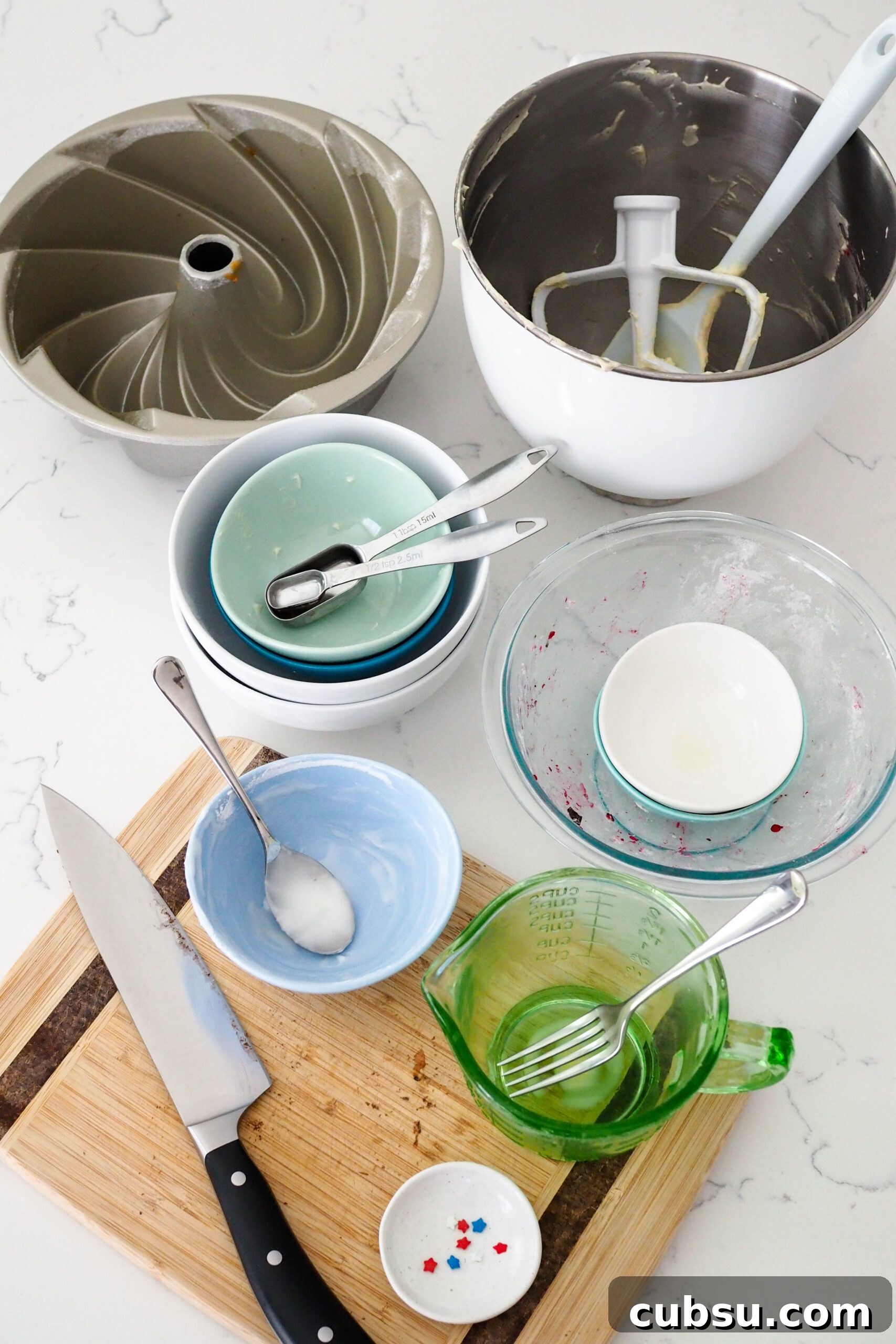 Dishes used to make berry Bundt cake on a counter.