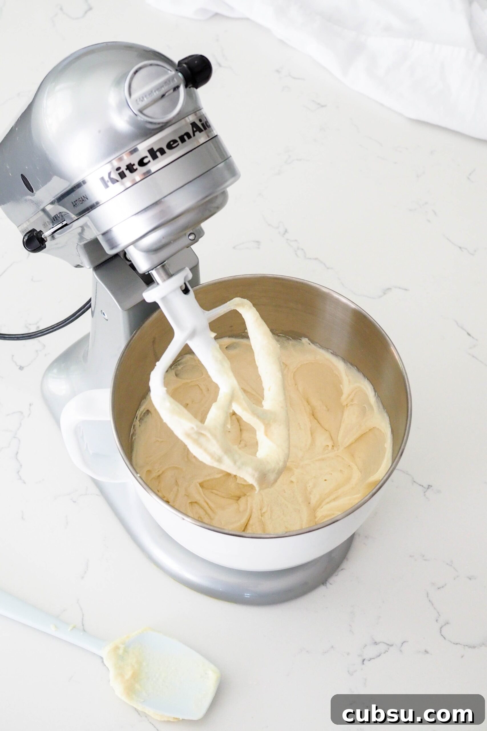 A fluffy Bundt cake batter inside of a stand mixer bowl.