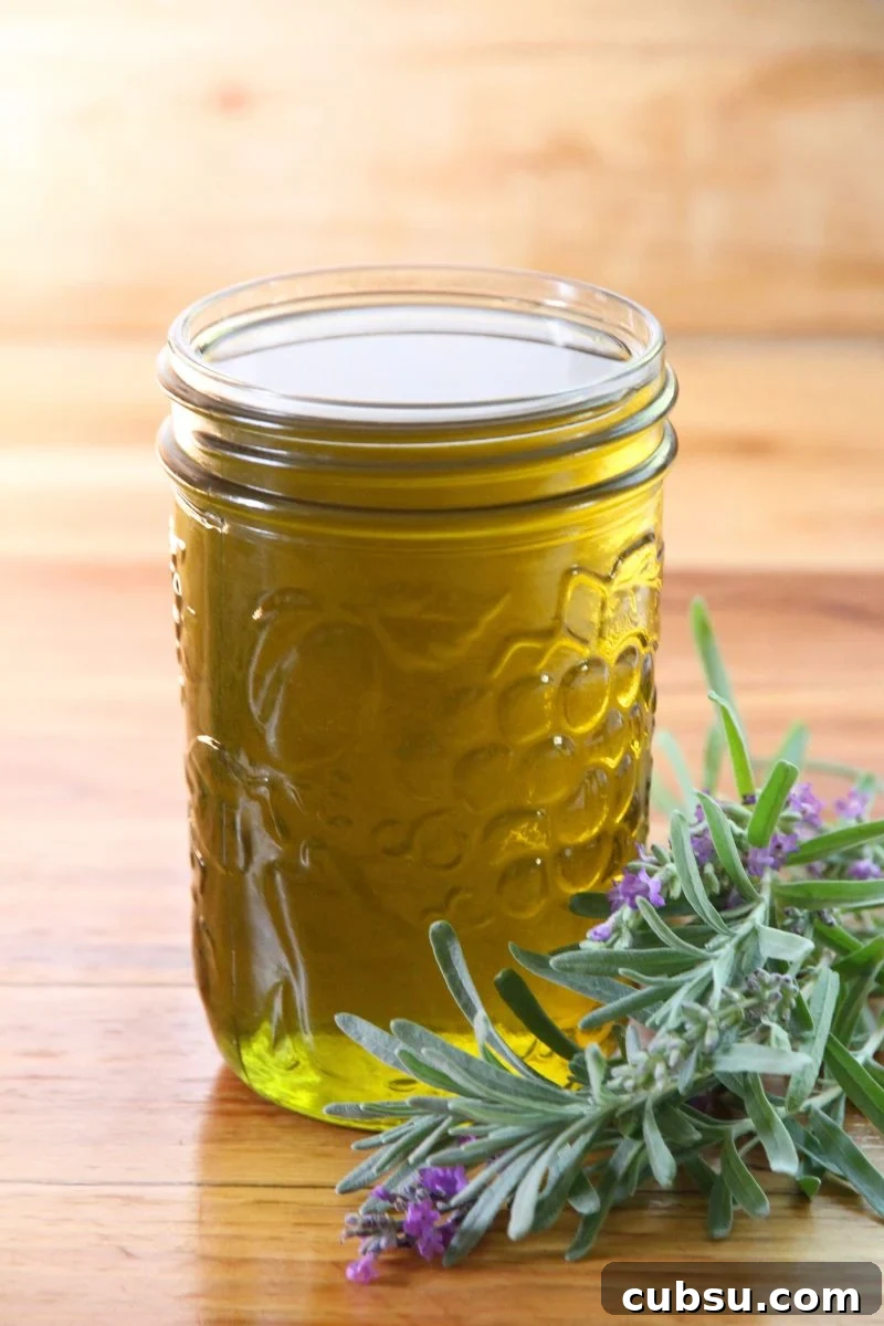 A jar of avocado infused lavender oil, with a fresh bundle of lavender beside.
