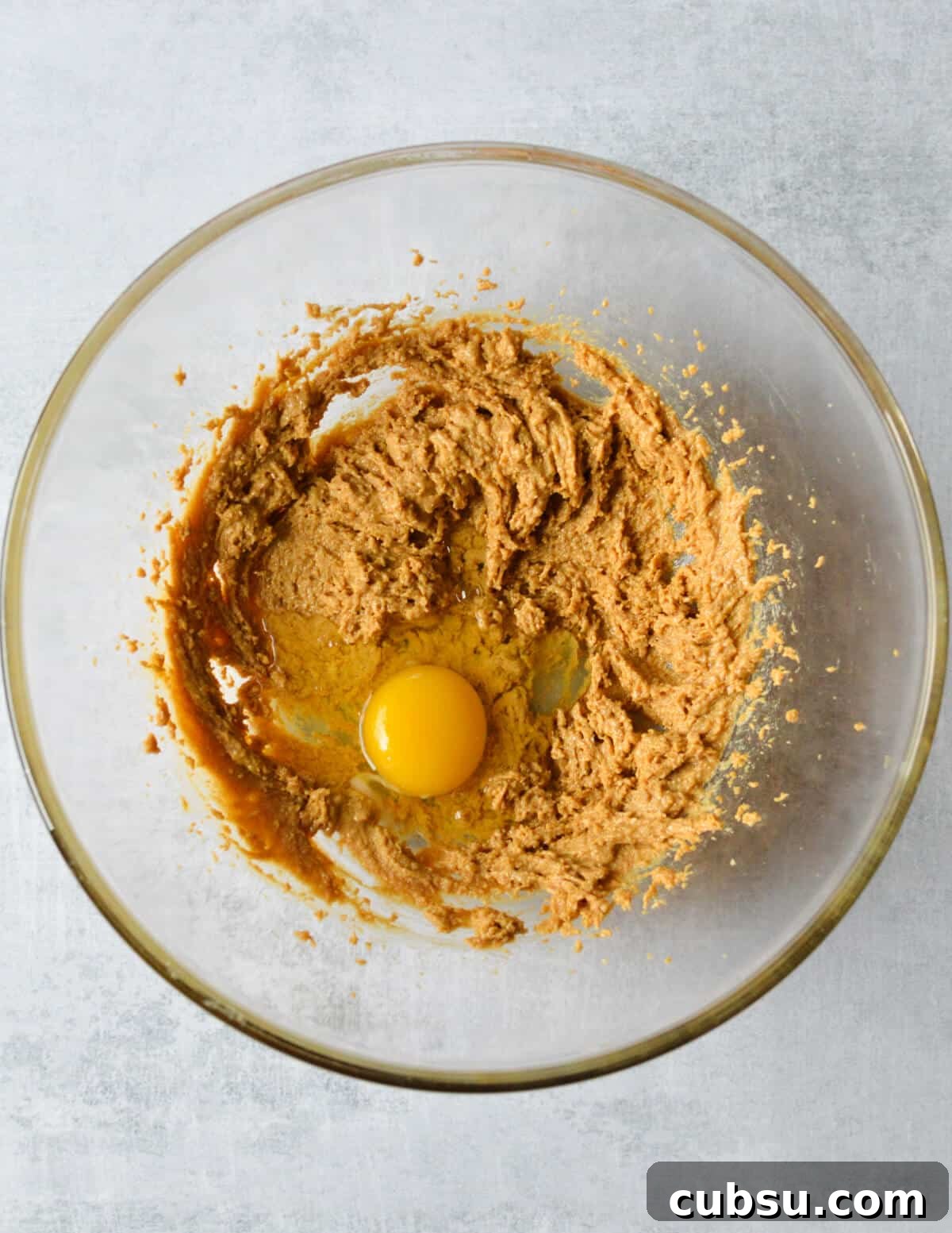 Flourless Peanut Butter Cookies Recipe — Chewy & Gluten-Free 6 whipped peanut butter and sugar with an egg on top in a bowl.