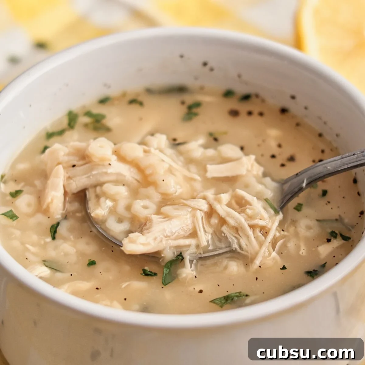 white bowl filled with lemon chicken pastina soup.