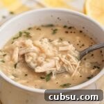 white bowl filled with lemon chicken pastina soup.