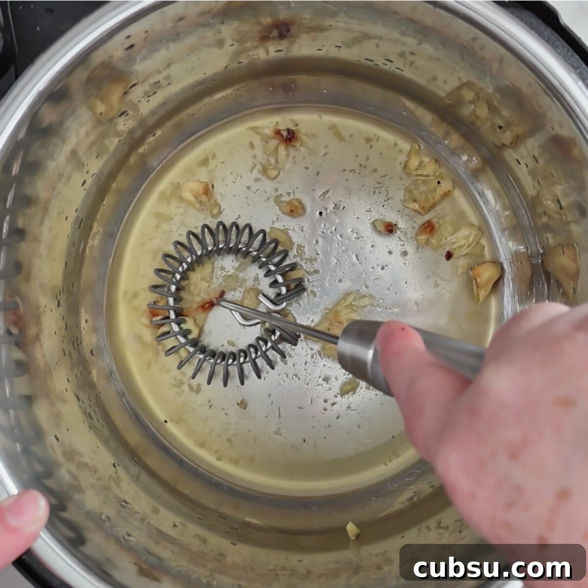mashing roasted garlic into a little bit of broth in instant pot.