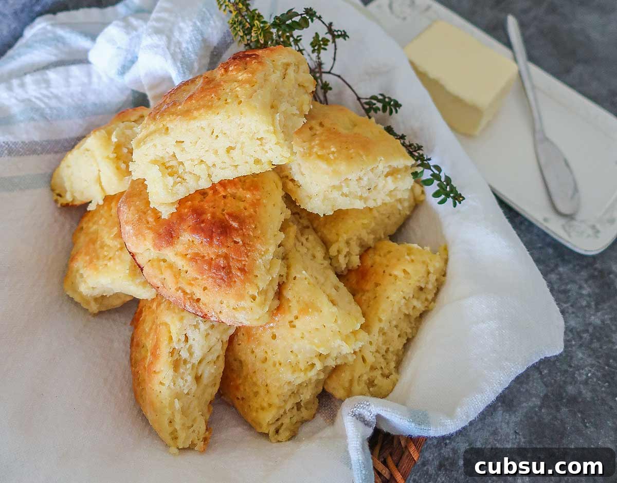 gluten free milk rolls in a towel with butter dish on the side