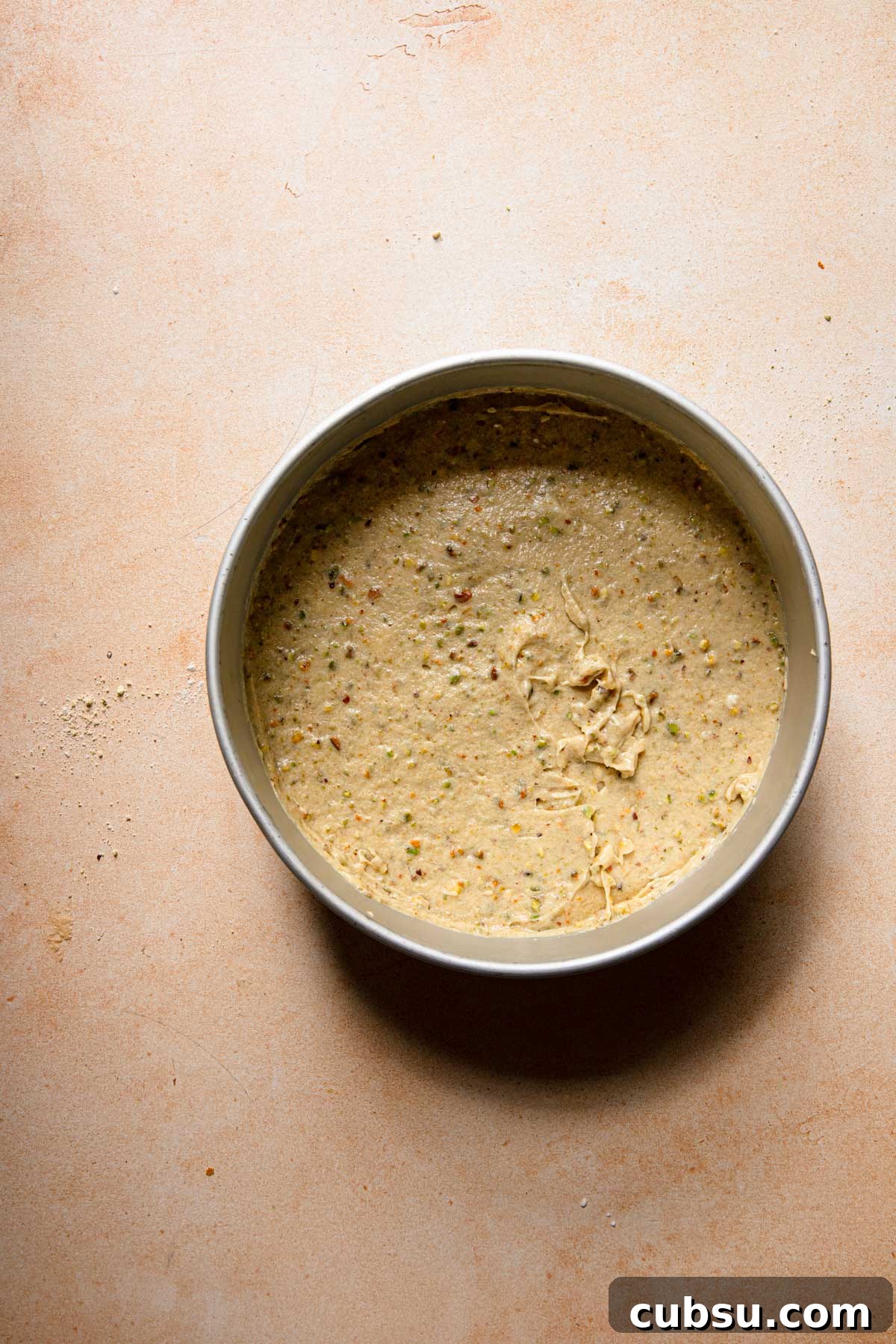 A pan with unbaked pistachio cake batter.