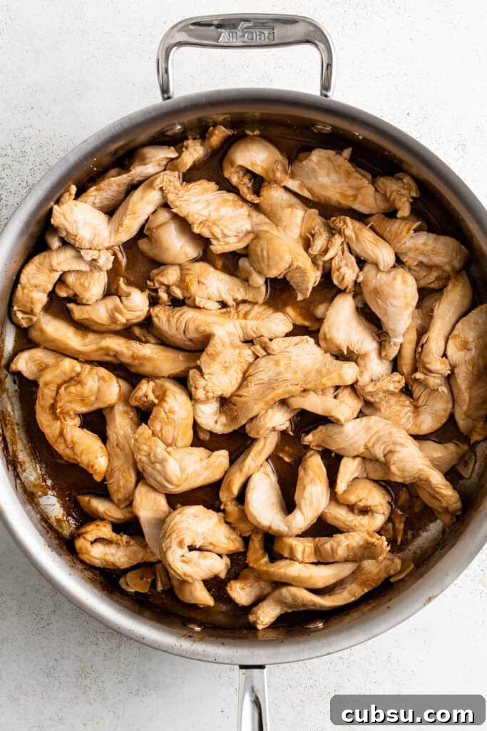Browning thinly sliced chicken in a pan.