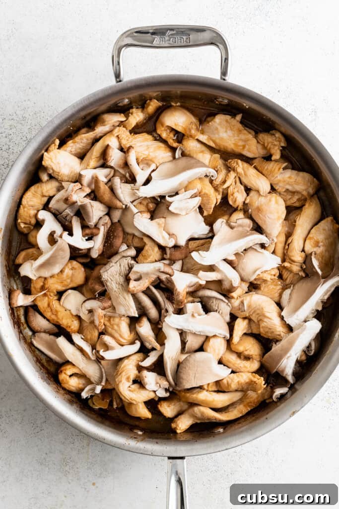Adding shiitake mushrooms to a pan with browned chicken.