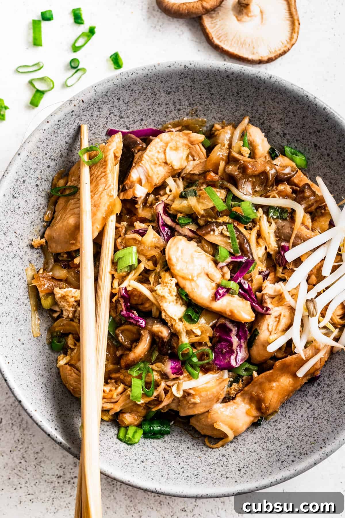 Moo shu chicken in a bowl with chopsticks.