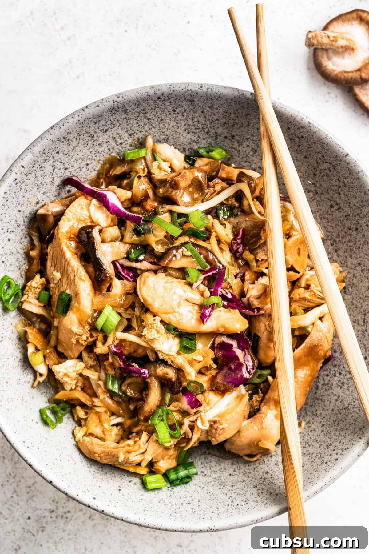 Moo shu chicken in a bowl with chopsticks.