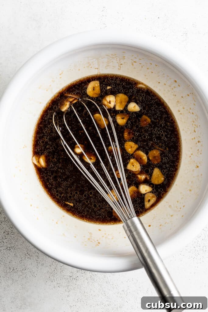 Asian marinade in a bowl with a whisk.