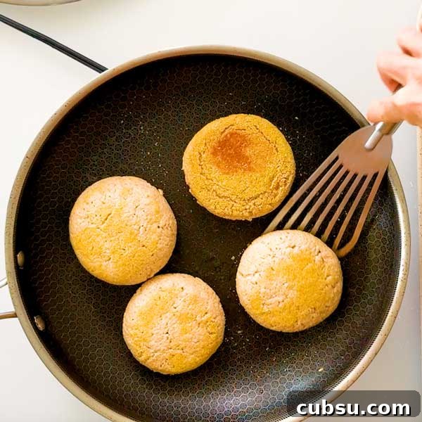 Flipping English muffins over in a skillet.
