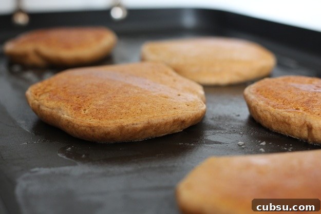 How to Store Leftover Pancakes So They Stay Fresh 2 Pancakes cooking on the griddle.