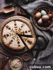 A rustic milk tart on a table with eggs, tablecloth, and cinnamon.