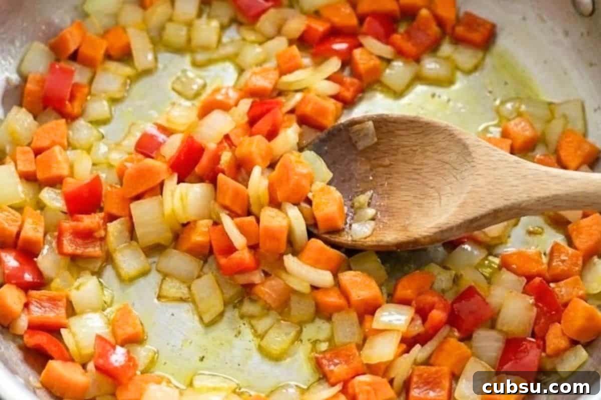 Heat the oil in a large pan over medium high heat and add the onion, carrots, and capsicum.
