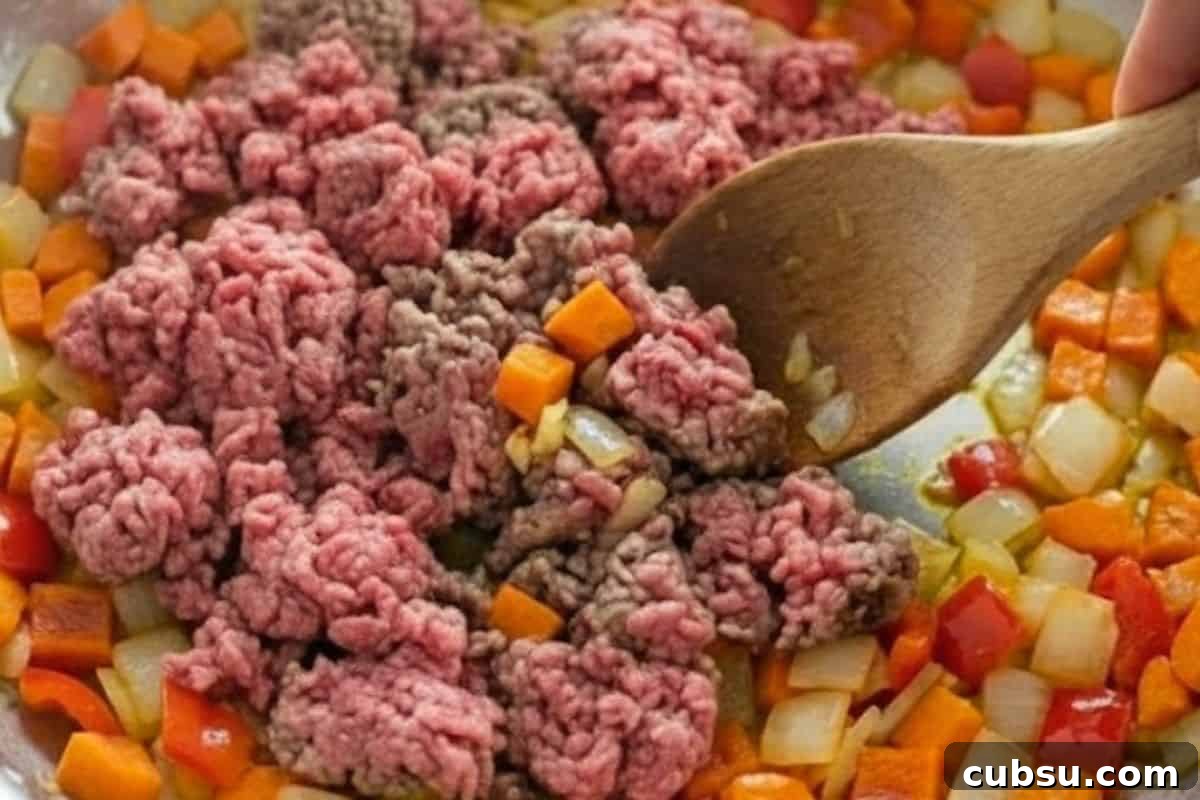 Add ground beef and break it apart as it cooks.