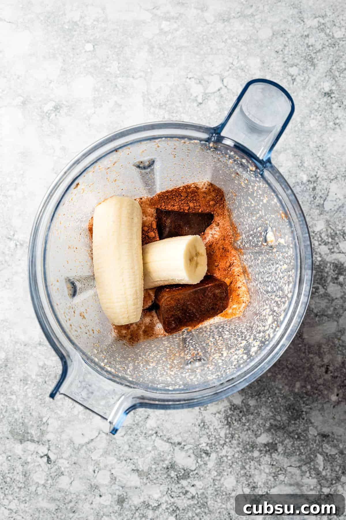 Combine the ingredients. A banana and coffee ice cubes in a blender.