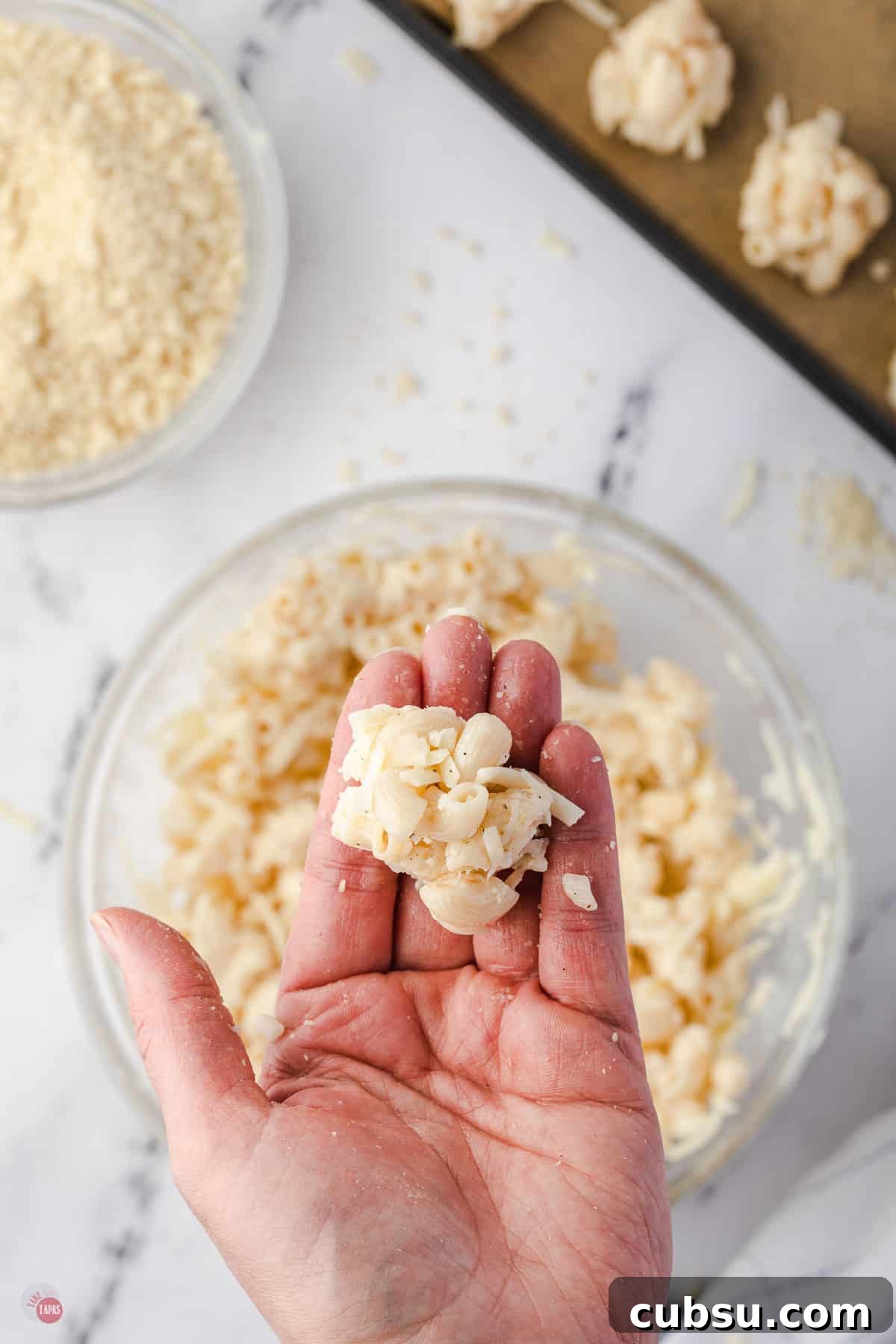 hand holding a ball of mac and cheese