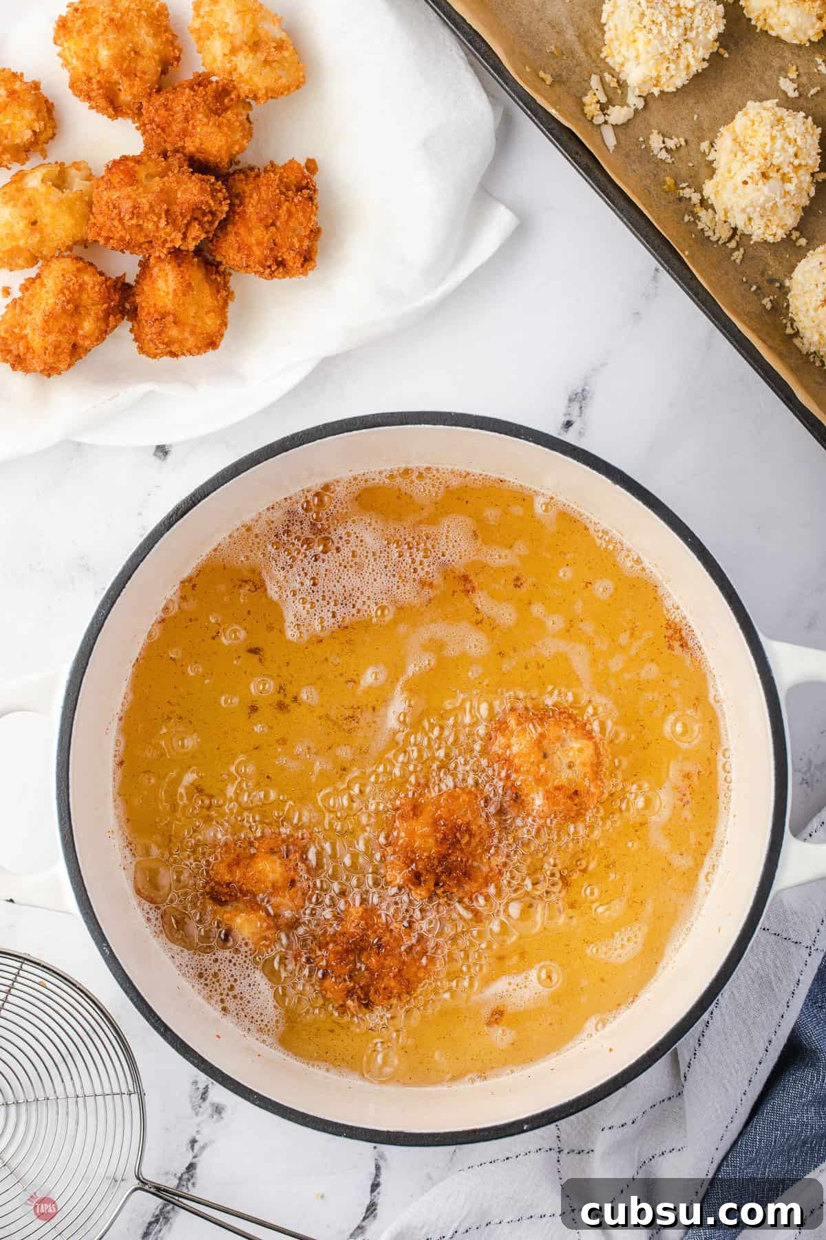 balls frying in oil in a pot