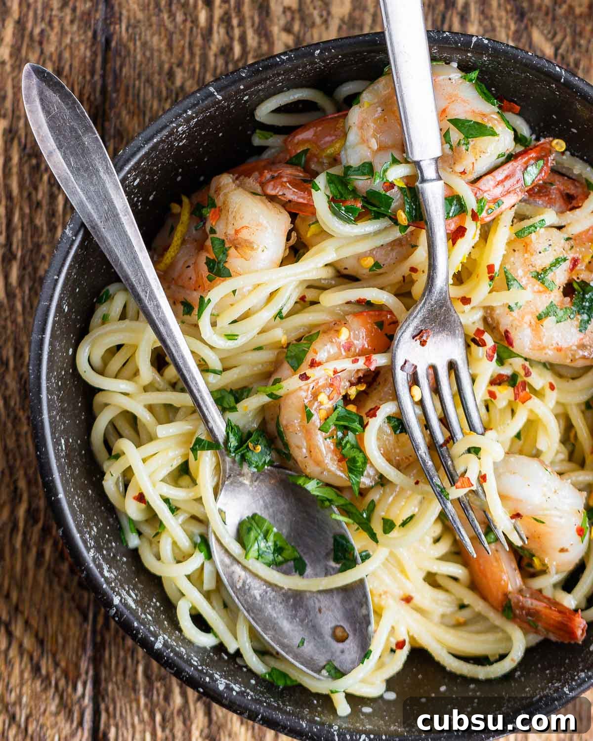 Lemon Garlic Shrimp Pasta Recipe — Zesty Weeknight Dinner 6 Lemon garlic shrimp pasta in black plate on table.