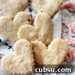 heart shaped lavender shortbread stacked on a white cloth.