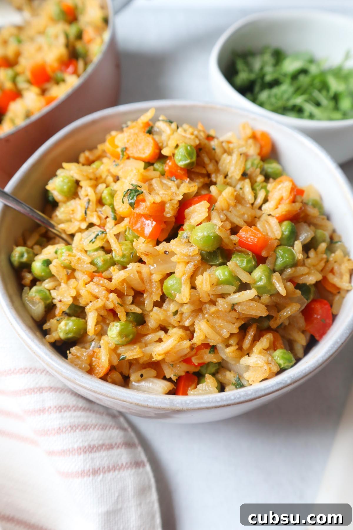 Green Curry Fried Rice Recipe: Authentic Thai Flavor in 30 Minutes 2 green curry fried rice in a white bowl with carrots, peas, and pepper, topped with fresh cilantro