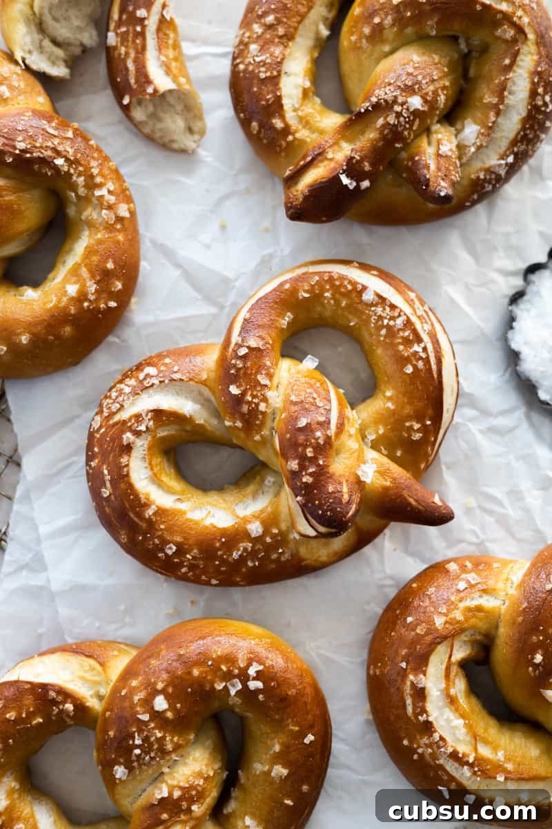 Crispy Sourdough Discard Pretzels: Tangy Soft-Baked Recipe 2 Sourdough discard pretzels on white parchment paper.