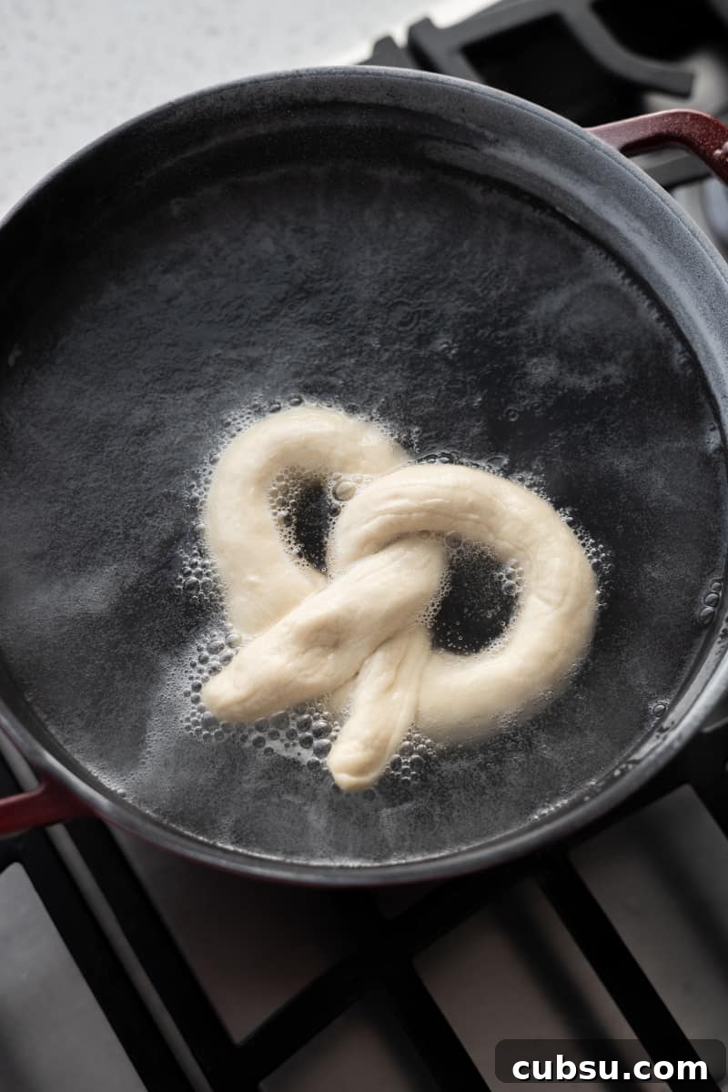 Crispy Sourdough Discard Pretzels: Tangy Soft-Baked Recipe 11 Pretzel boiling in a pot of water.