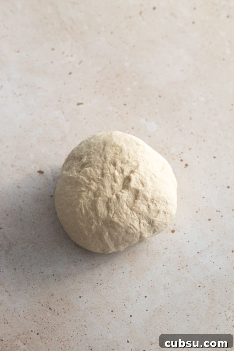 Crispy Sourdough Discard Pretzels: Tangy Soft-Baked Recipe 5 Dough ball on a work surface.