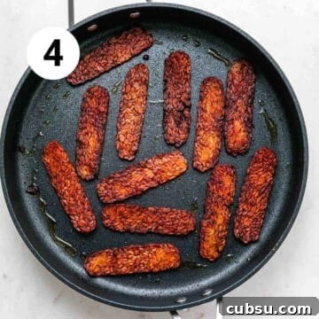 Crispy Tempeh Bacon Recipe: Smoky Vegan Bacon Alternative 13 Cooked tempeh bacon in a large skillet.