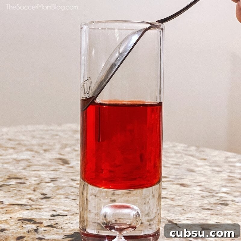 Festive Tipsy Santa Shooters Recipe for Holiday Parties 6 using a spoon to make a layered shot
