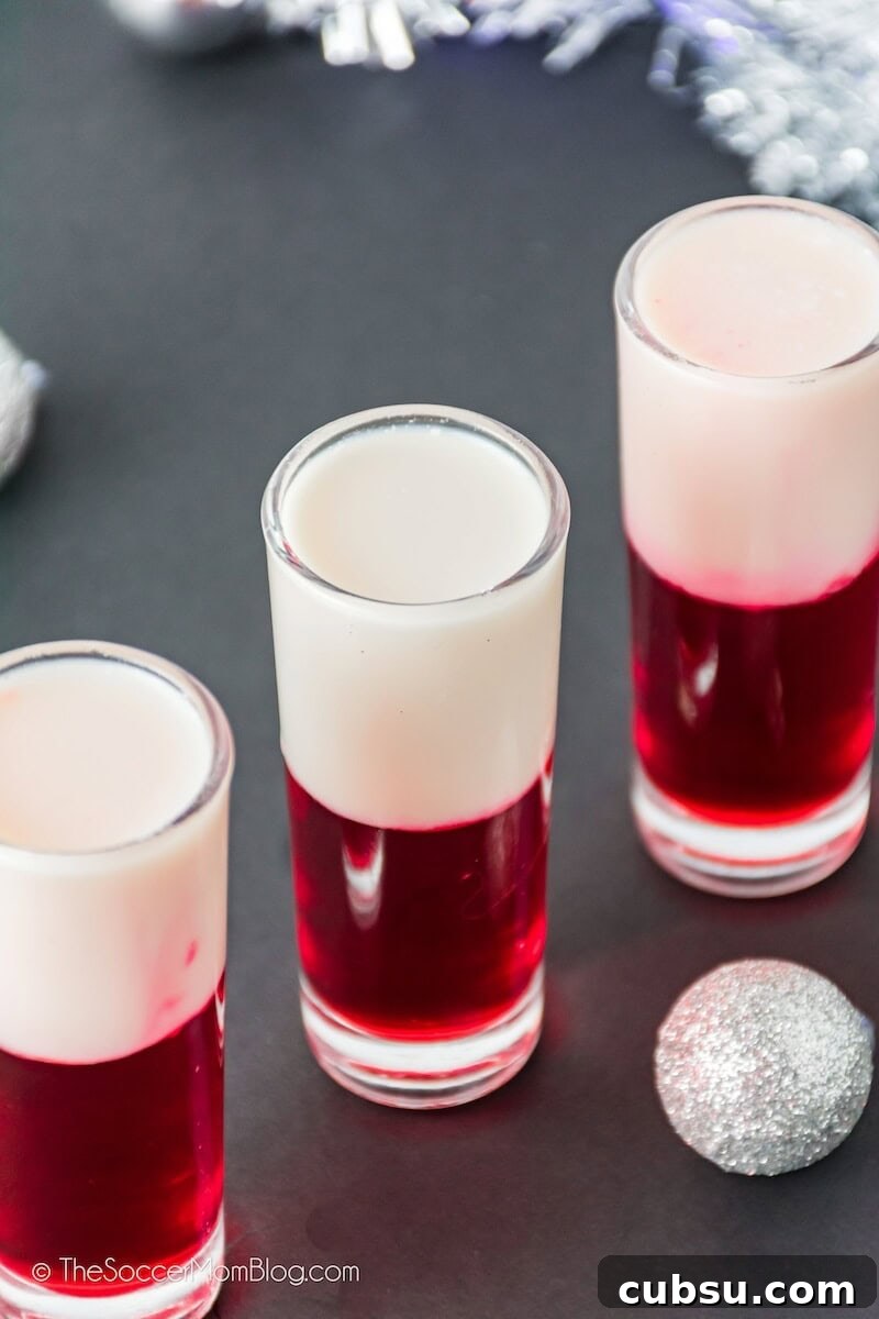 Festive Tipsy Santa Shooters Recipe for Holiday Parties 7 red and white layered shooters in tall shot glasses