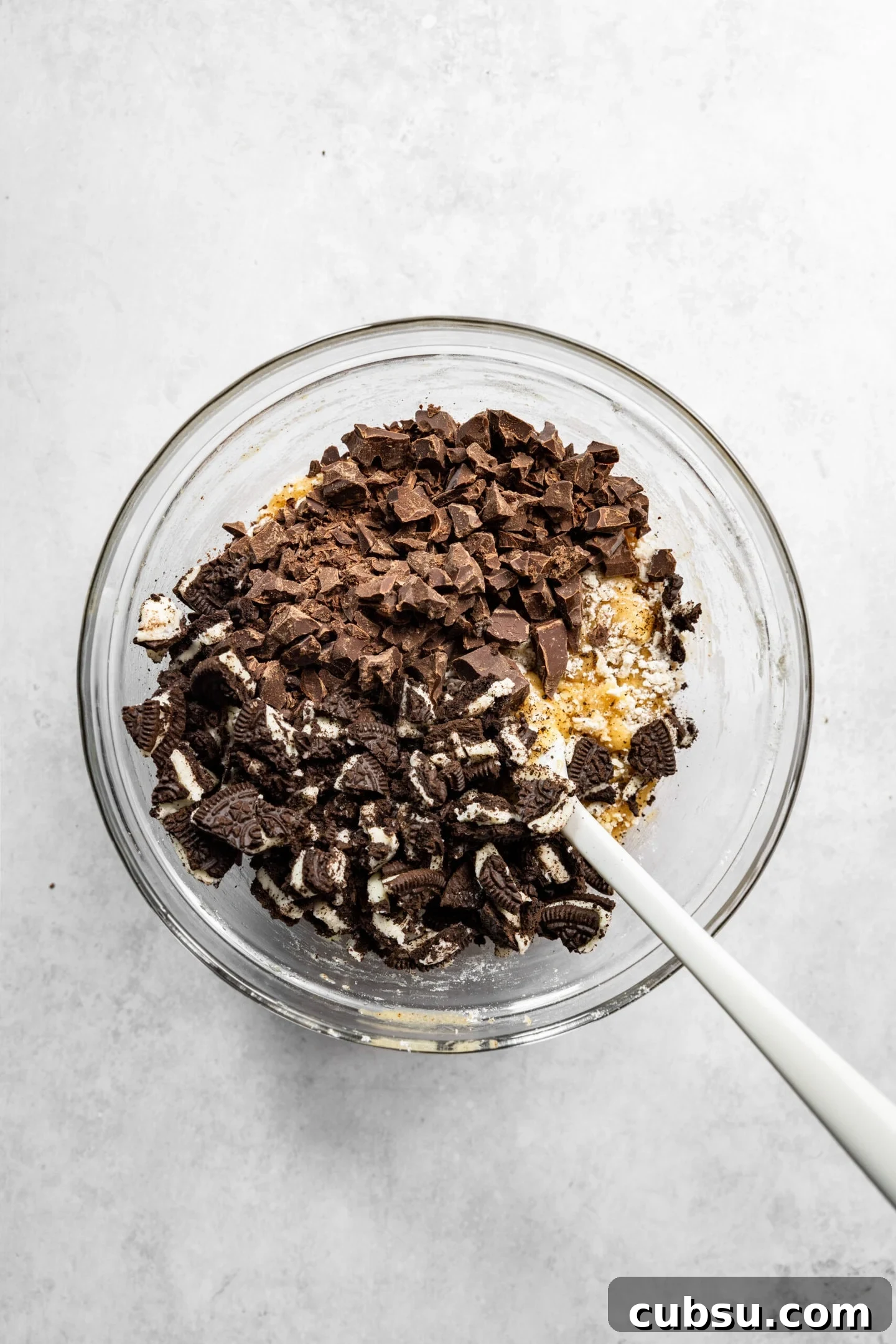 Chewy Oreo Chocolate Chip Cookies Recipe for Ultimate Indulgence 8 Chocolate chunks and Oreos being stirred into cookie dough