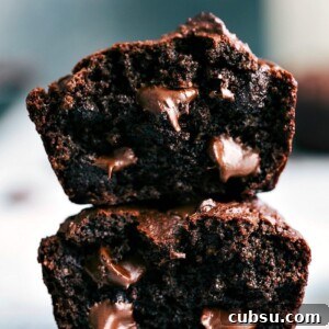 Chocolate Peanut Butter Muffins Recipe — Moist & Decadent 3 Chocolate peanut butter muffins, cut in half and stacked, revealing their soft interior with gooey chocolate chips.
