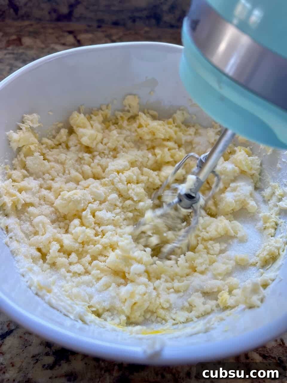 Sourdough Sugar Cookie Bars Recipe — Buttery Soft Cookie Bars 4 A bowl of butter and sugars being creamed together with a hand mixer.
