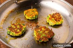 Close up of pan fried broccoli fritters with feta cheese, showing a golden crust and tender texture inside.