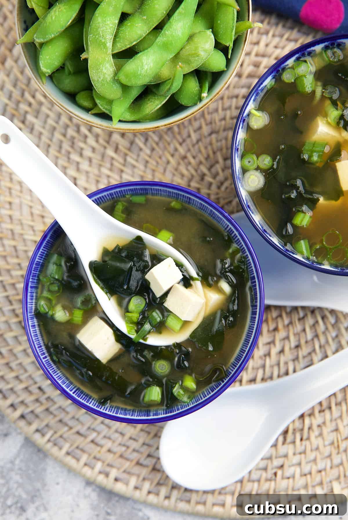 Authentic Miso Soup Recipe for Fast Weeknight Meals 2 A white spoon is lifting a bite sized portion of soup from the bowl.