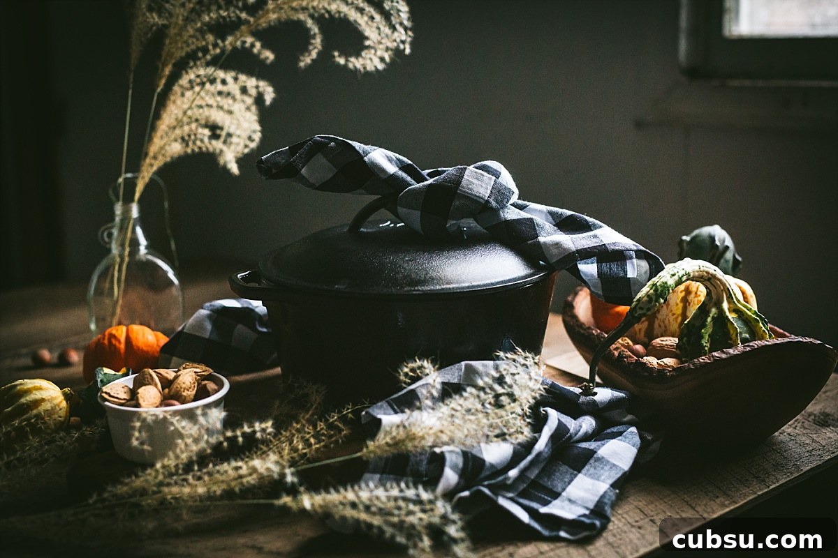 cast iron pot full of beef bbq with black and white checked napkin tied on top