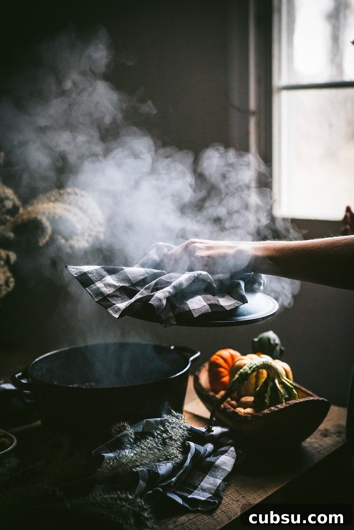 huge cloud of steam rises from cast iron pot full of shredded beef